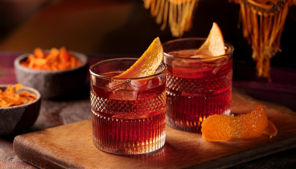 Close-up of two Montelobos Mezcal Negroni cocktails with orange peel garnish