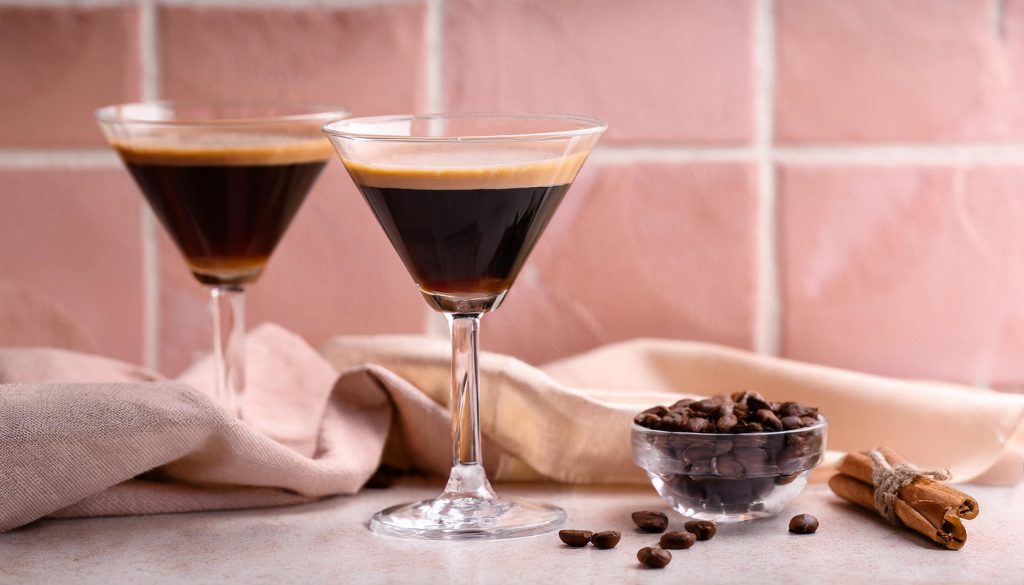 Two Cinnamon Espresso Martinis styled against a pale pink tiled background