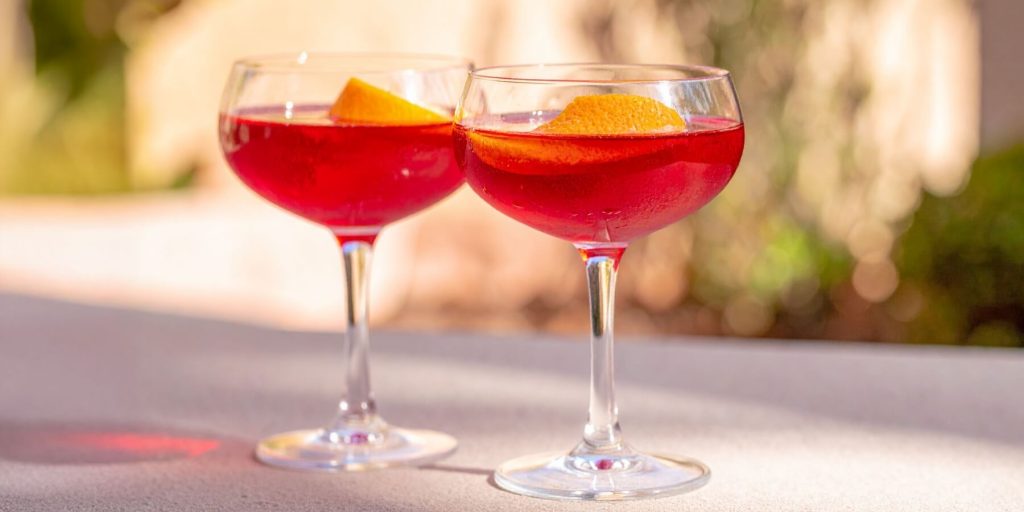 Two vibrant Negroni Up cocktails with orange peel garnish