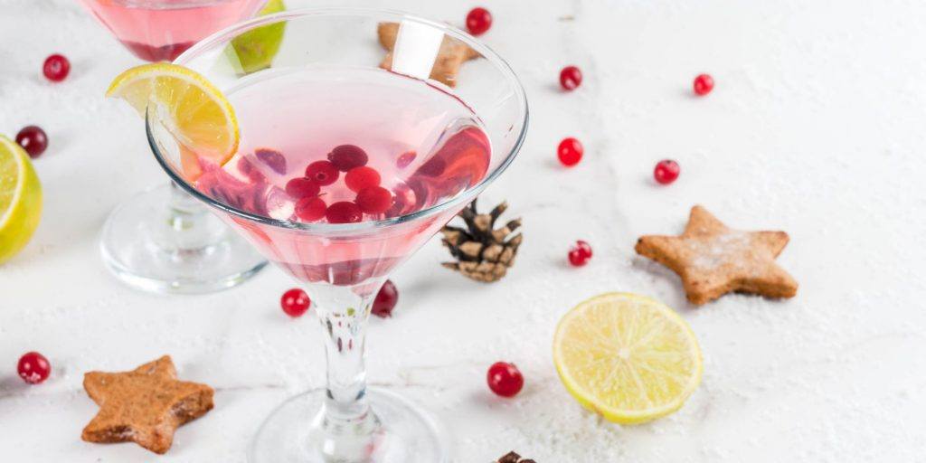 A festive Cranberry Martini cocktail with a sugared rim and fresh cranberries.