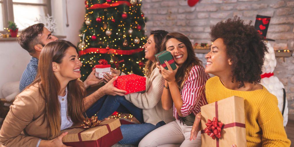 A festive Christmas cocktail party scene with guests exchanging humorous gifts.