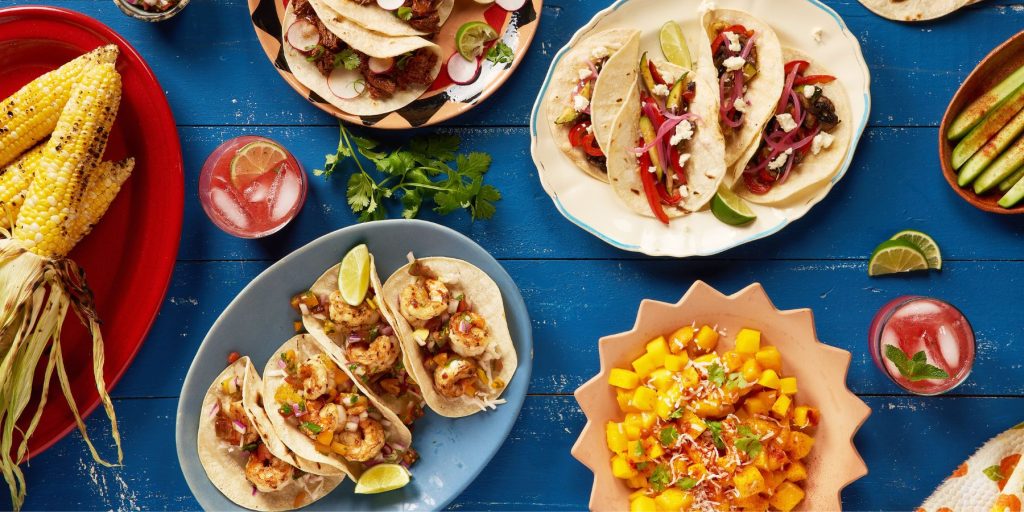 Vibrant Mexican feast setup for Cinco de Mayo with colorful decorations and food.